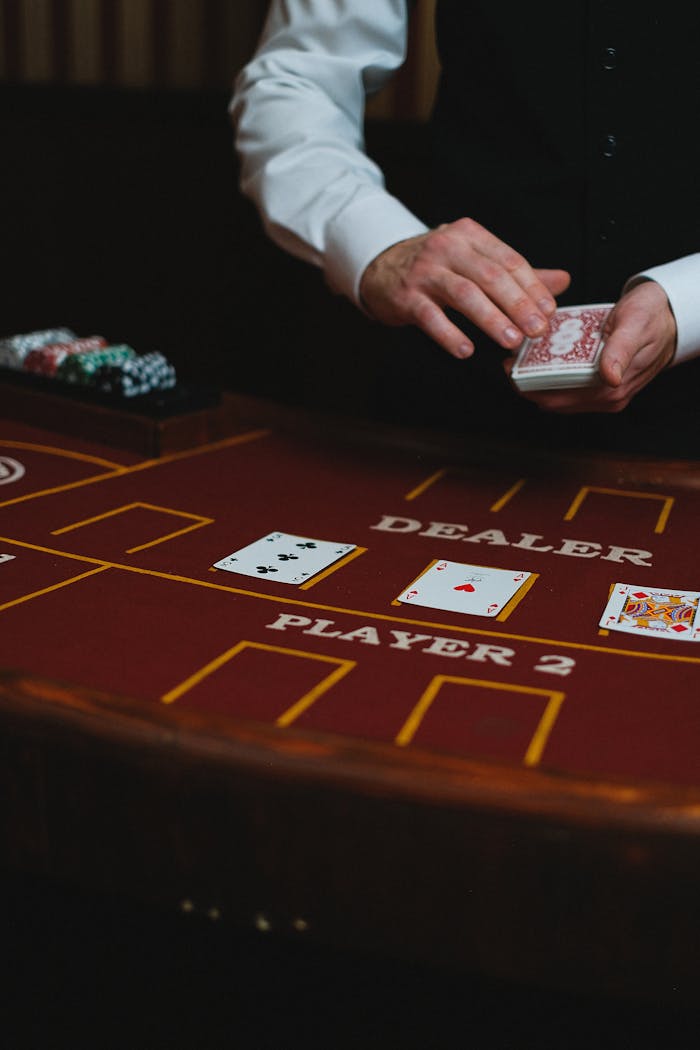 Close-up of a casino dealer dealing cards on a gaming table during a gambling session.